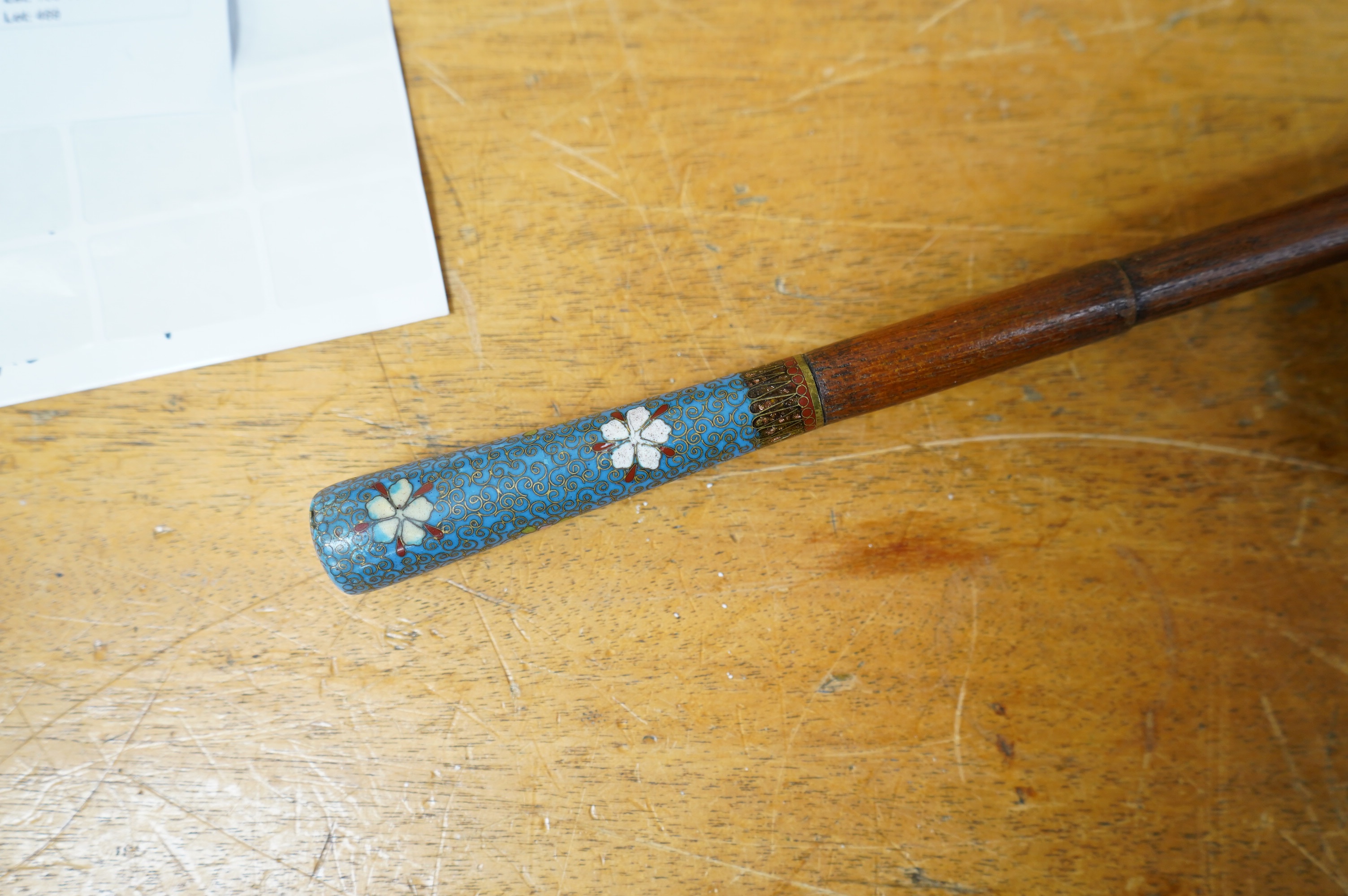 An early 20th century erotica walking stick with cloisonne handle and concealed whip, engraved 'Frida, Le One Two Two'